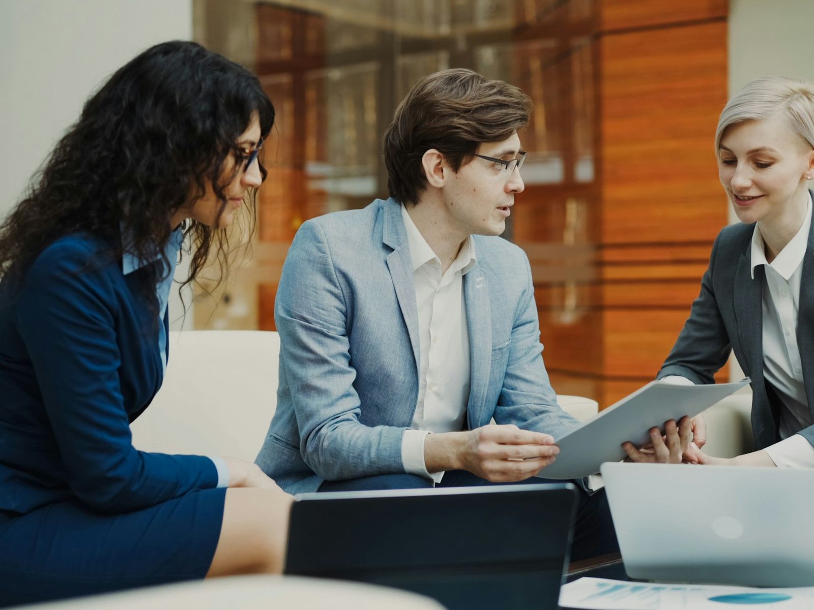 Three professionals reviewing a document together at a meeting table